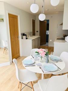 una mesa blanca con sillas blancas y una cocina blanca en 'The Limes' - Air-Con Two Double Bedroom Holiday House with Private Garden en Kent