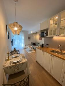 a kitchen with a table and a living room at Apartments Fantasia in Pula