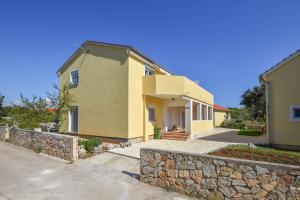 a house with a stone wall at Apartments Sunset in Olib