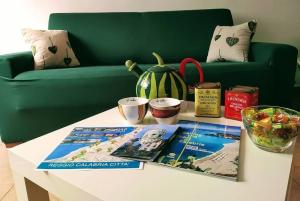 einen weißen Couchtisch mit Büchern und eine grüne Couch in der Unterkunft La casa di Francesca in Reggio di Calabria