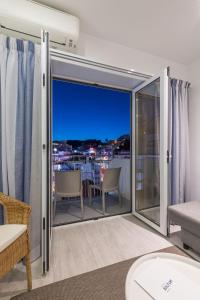 a room with a balcony with a view of a city at Hotel Baltum in Albufeira