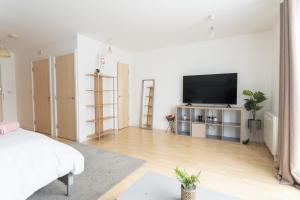 a living room with a tv and a bed at Modern Spacious studio close to station in London