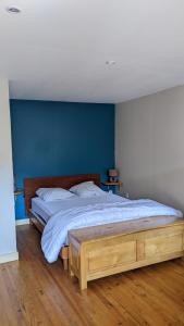 - une chambre avec un grand lit et un mur bleu dans l'établissement Gîte-La Combelle, à Dornas