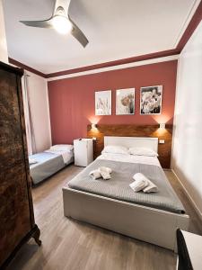 ローマにあるNova Roma Guest Houseのベッドルーム1室(ベッド2台、シーリングファン付)