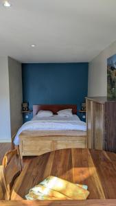 1 dormitorio con 1 cama con pared azul en Gîte-La Combelle, en Dornas