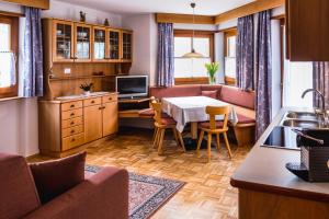 Una cocina y una sala de estar con una mesa y un sofá. en Apartment Suliva, en Santa Cristina Valgardena