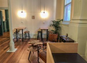 a room with bar stools and tables in a building at Roamer St Kilda - formerly Selina St Kilda Melbourne in Melbourne