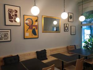 a dining room with two tables and a couch at Roamer St Kilda - formerly Selina St Kilda Melbourne in Melbourne