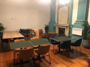 a room with tables and chairs and a fireplace at Roamer St Kilda - formerly Selina St Kilda Melbourne in Melbourne