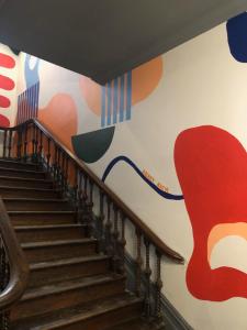 a staircase with a mural on the wall at Roamer St Kilda - formerly Selina St Kilda Melbourne in Melbourne