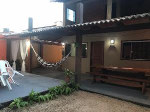 un porche de una casa con hamaca y banco en Casa da Belinha, en Pirenópolis