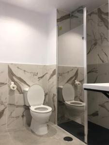 een badkamer met 2 toiletten en een douche bij Hostal Santa Calma in Marbella