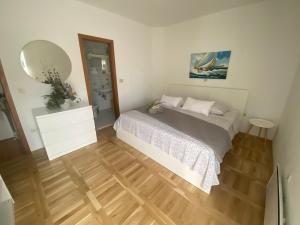 a small bedroom with a bed and a mirror at Apartment and room Hoselito in Makarska