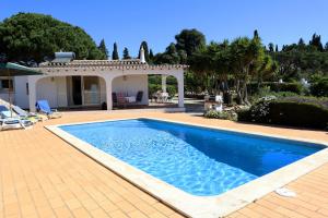 una piscina davanti a una casa di Villa Laranjal a Mexilhoeira Grande