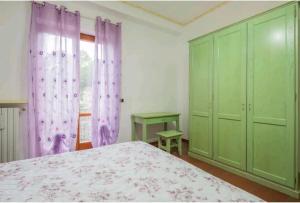 una camera con letto, tende viola e finestra di La Calcara di Nonno Raffaele ad Agerola