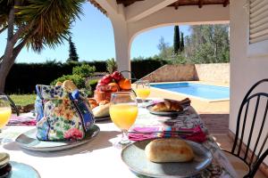 un tavolo con piatti di cibo e bicchieri di succo d'arancia di Villa Laranjal a Mexilhoeira Grande