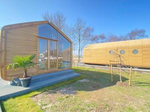 a small wooden house with a tree in front of it at Wikkelhuis 30 in Stavoren