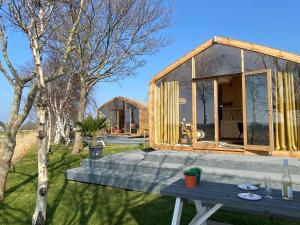 a glass house with a picnic table in the yard at Wikkelhuis 30 in Stavoren