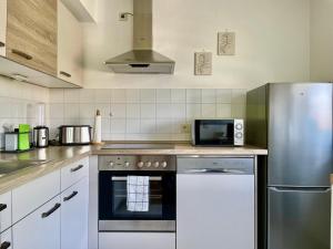 a kitchen with a stove and a refrigerator at Design Oase 70 qm - Zentrumsnähe mit Küche in Renningen