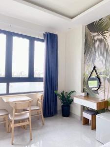 a living room with a table and a blue curtain at HOSTEL ARIA in Quy Nhon