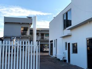 a white fence in front of a white building at Hotel Hawaii in Colíder