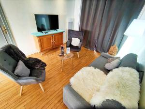 a living room with a couch and two chairs and a tv at BALNEO 100M PLAGE JARDIN BRASERO in Berck-sur-Mer