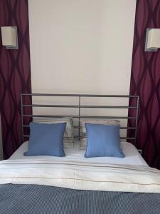 łóżko z dwoma niebieskimi poduszkami na górze w obiekcie Panama Apartament 3 Poznań w Poznaniu