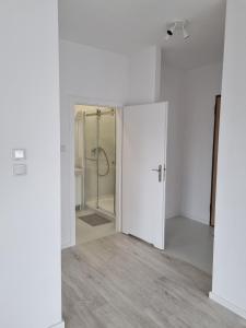 Habitación vacía con ducha y puerta de cristal en Apartament Chrobrego, en Gdansk