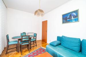 a living room with a blue couch and a table at Apartments Peco in Mokošica