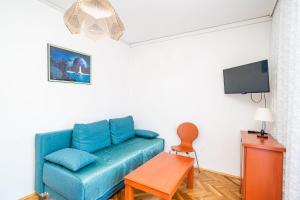 a living room with a blue couch and a tv at Apartments Peco in Mokošica