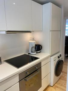 cocina con armarios blancos, lavadora y secadora en Cozy apartment in elegant Østerbro, en Copenhague