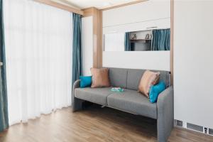 a living room with a gray couch and blue pillows at Higher Moor Farm in Weymouth