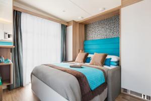1 dormitorio con 1 cama grande y cabecero azul en Higher Moor Farm, en Weymouth