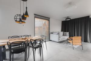 jadalnia ze stołem, krzesłami i kanapą w obiekcie Mazurski Dom nad Jeziorem & Sauna by Downtown Apartments w mieście Tomaszkowo