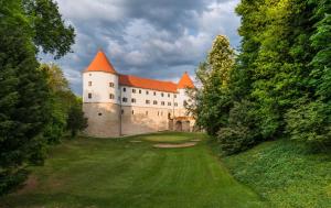 a castle in the middle of a green field at Mokrice Castle Estate in Čatež ob Savi