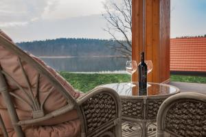 szklankę wina siedzącą na stole na ganku w obiekcie Mazurski Dom nad Jeziorem & Sauna by Downtown Apartments w mieście Tomaszkowo +37 zdjęć