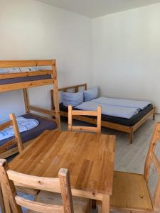 a room with two bunk beds and a table at Tauchbasis Stechlin in Stechlin