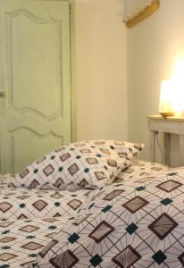 een bed met een dekbed en een kussen erop bij La Chtite Maison Béarnaise in Arthez-de-Béarn