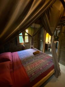 Cette chambre comprend un lit à baldaquin. dans l'établissement Balian Beach Villa, à Selemadeg