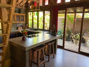 a kitchen with a large island in a room with windows at Balian Beach Villa in Selemadeg