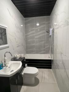 ein Badezimmer mit Toilette, Waschbecken und Badewanne in der Unterkunft The Bake Apartment - 5 bedroom Large Apartment sleeps up to 16 person in Newcastle upon Tyne