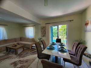 uma sala de estar com uma mesa e cadeiras e um sofá em Charming 3-Bed Villa in Protaras with heated pool em Protaras