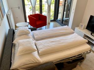 2 Betten in einem Zimmer mit einem roten Stuhl in der Unterkunft OnPoint in Zagreb
