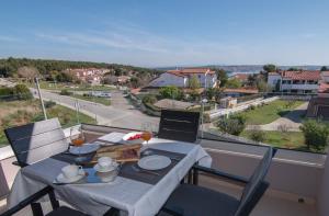 stół i krzesła na balkonie z widokiem na ulicę w obiekcie Luxury apartment Grotta with sea view and swimming pool w mieście Premantura