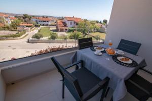 stół i krzesła na balkonie z widokiem w obiekcie Luxury apartment Grotta with sea view and swimming pool w mieście Premantura