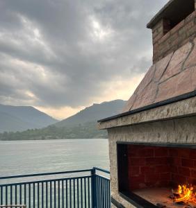 a building with a fireplace next to a body of water at Montana Apartmani in Konjic