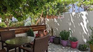 a patio with a table and chairs and potted plants at Pension Irene in Sougia