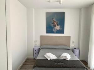 a bedroom with a bed and a painting on the wall at BN SUITES Teatro in Alicante