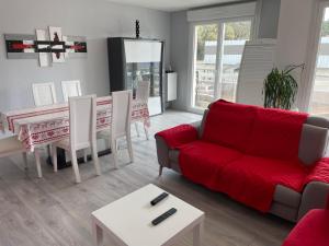 サン・ブルヴァン・レ・パンにあるRésidence le freeport2のリビングルーム(赤いソファ、テーブル付)