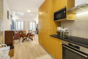 eine Küche und ein Wohnzimmer mit einem Tisch und Stühlen in der Unterkunft WHome Bairro Alto 2-Bed Central Location Fully Equipped in Lissabon